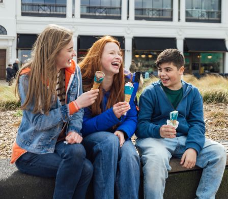 3 young people enjoying an ice-cream on the sea front